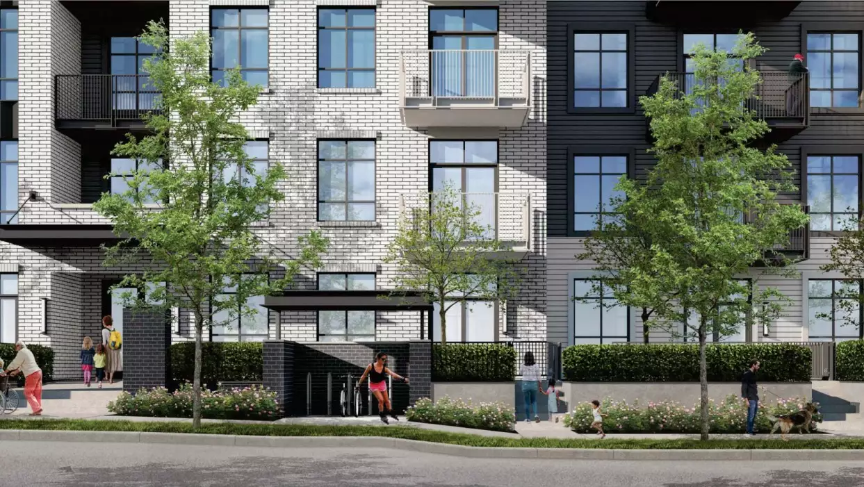 Grayson – A ground-level streetscape view of a modern multi-family residential building featuring a mix of white brick and dark grey siding facade materials. Pedestrians, including families and a person walking a dog, move along the paved sidewalk lined with young leafy trees, flower beds, and low hedges in bright daylight.