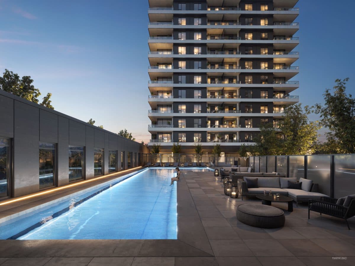 Band Condos – Rooftop lap pool at dusk with lounge seating and the tower's balconies rising above, a swimmer resting at the pool edge.
