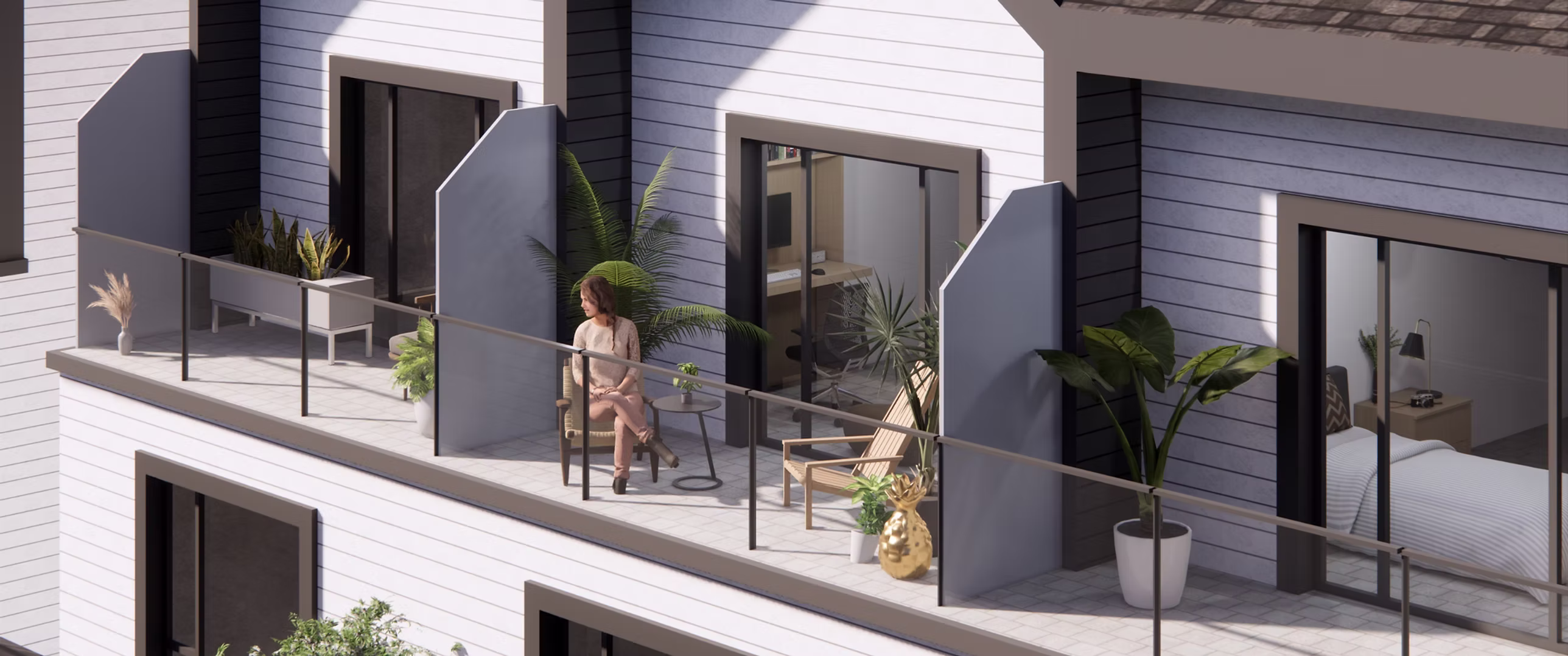8899 Spires – A woman sits on a sunny, modern townhouse balcony decorated with lush potted plants, outdoor chairs, and a small drinks table. The facade features horizontal white siding with dark trim framing glass sliding doors that open into stylish indoor living spaces.