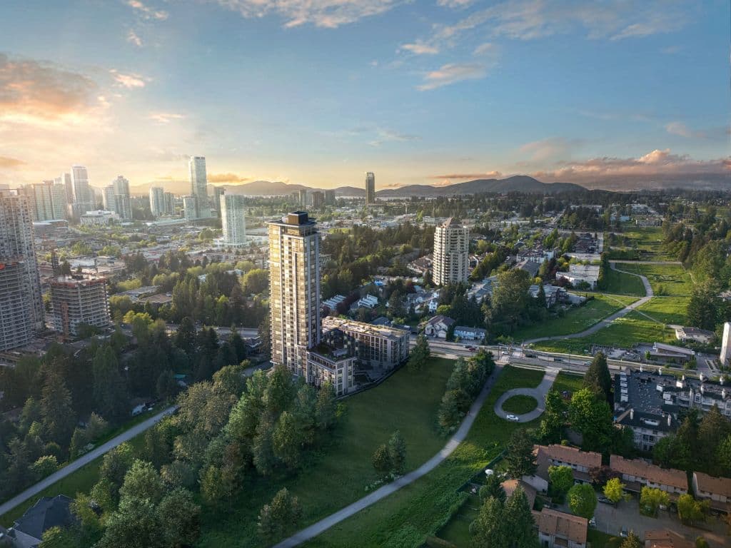 SkyLiving – A daytime aerial photo of a high-rise tower surrounded by trees and a suburban neighbourhood, with a city skyline and mountains at sunset in the distance.