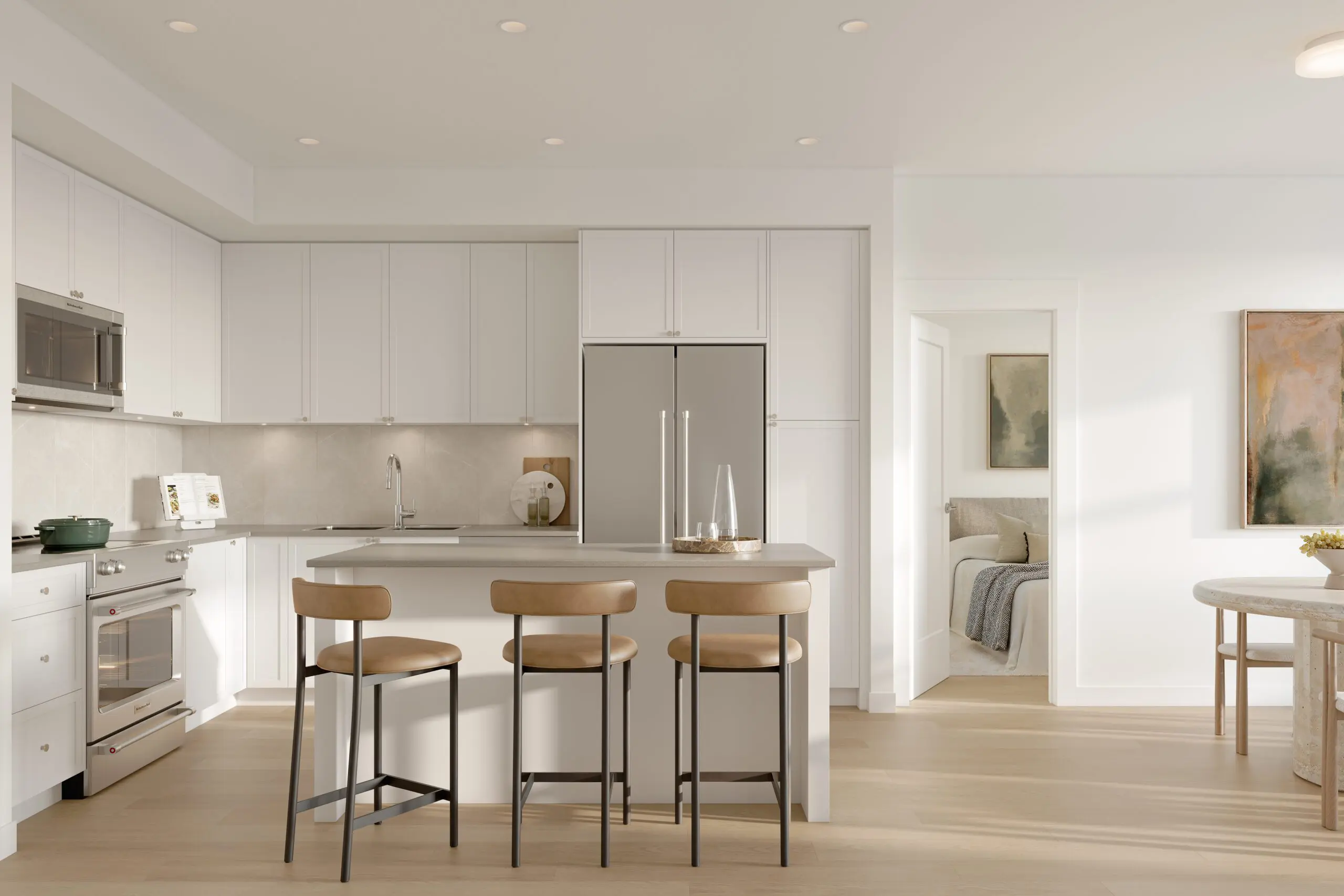 Fleetwood Village 2 – Open-concept kitchen with white shaker cabinets, a stainless fridge, gray island with bar stools, and a view through to a bedroom and dining area.