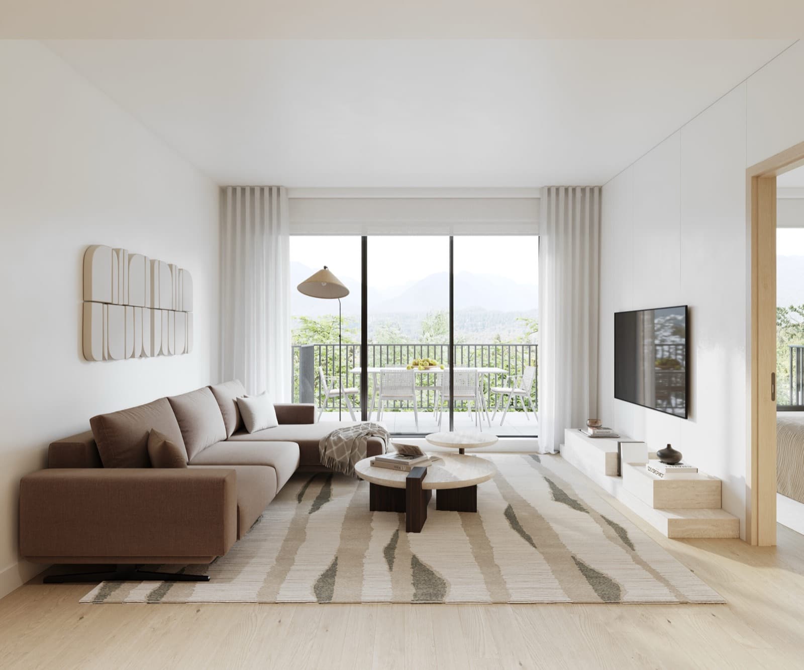 Siena – A living room with a brown sectional sofa, a wall-mounted abstract art piece, a wall-mounted TV, and floor-to-ceiling windows opening to a balcony with a dining set and mountain view.