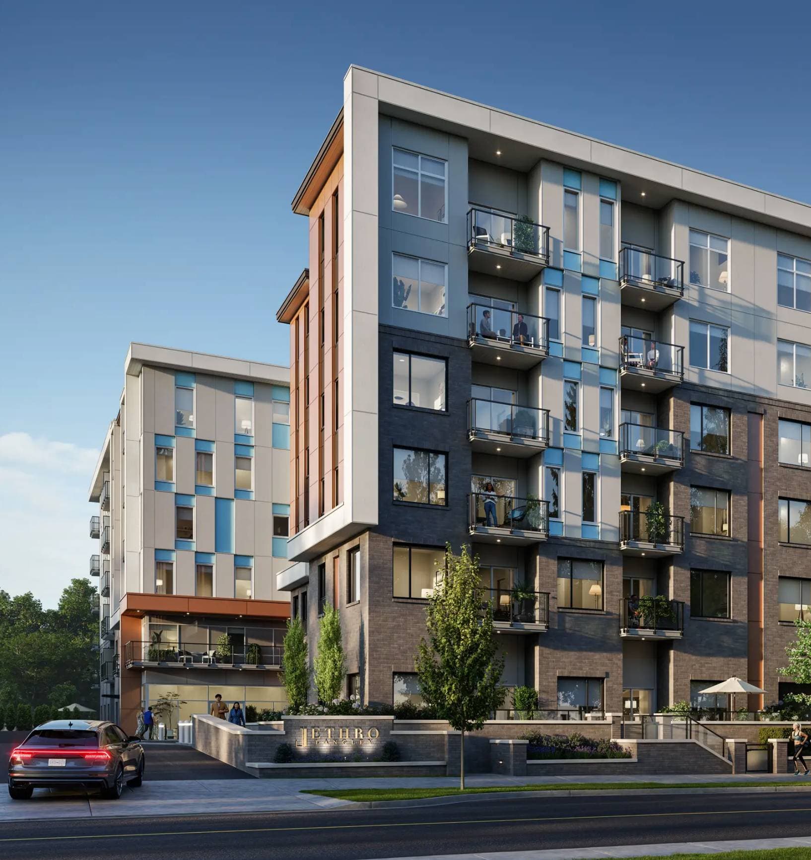 Jethro – Street-level view of the Jethro Langley building entrance with a mixed brick, blue-glass, and grey-panel facade, tiered balconies, and building signage at the base.