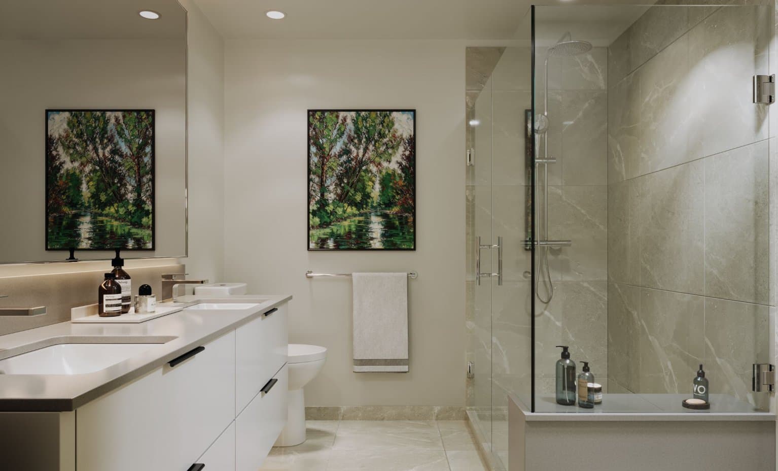 Stirling Block – Bathroom photo with a white double vanity, large mirror, framed tree artwork, and a glass-enclosed shower/tub with rain showerhead and marble tile.
