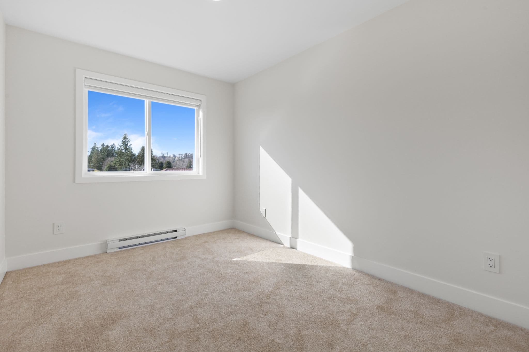 Clearbrook Commons – Unfurnished bedroom with carpeted floor, white painted walls, baseboard heating, and window.