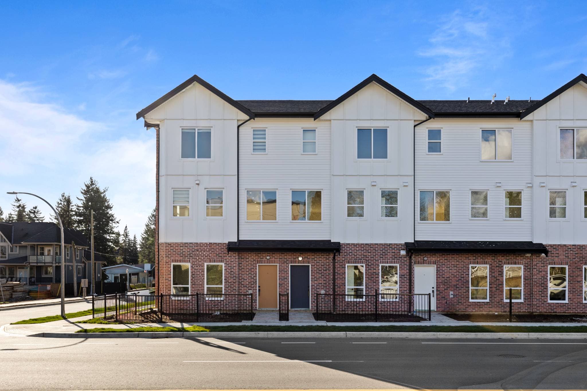 Clearbrook Commons – Front view of the multi-unit townhome building exterior with red brick lower level and white upper siding.