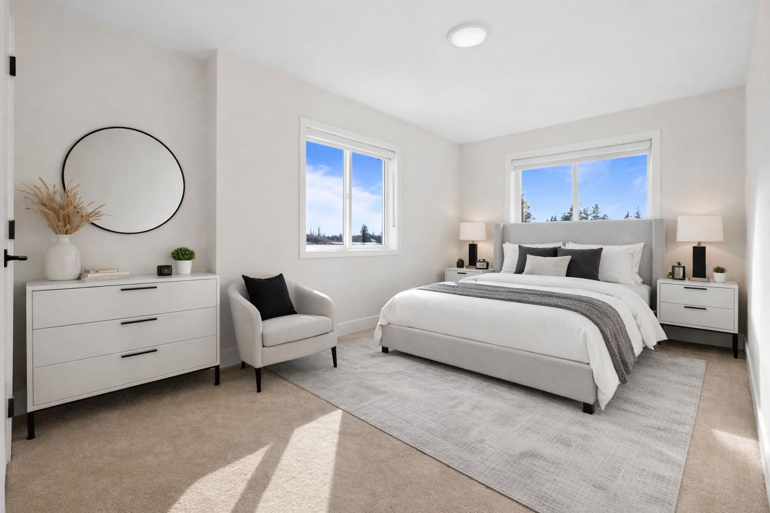 Clearbrook Commons – Primary bedroom featuring neutral carpet, upholstered bed frame, side table with lamp, and white three-drawer dresser.