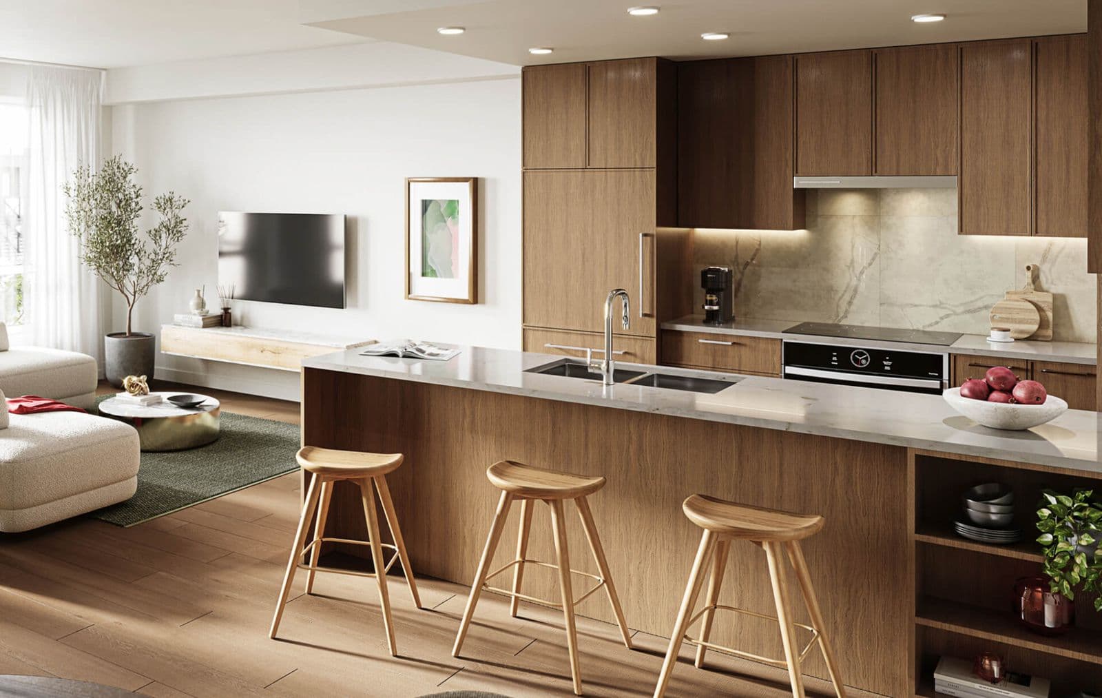 Kestrel – Kitchen island with white marble-look countertop, dark wood cabinetry, cooktop, and a bowl of pomegranates, living room in the background.