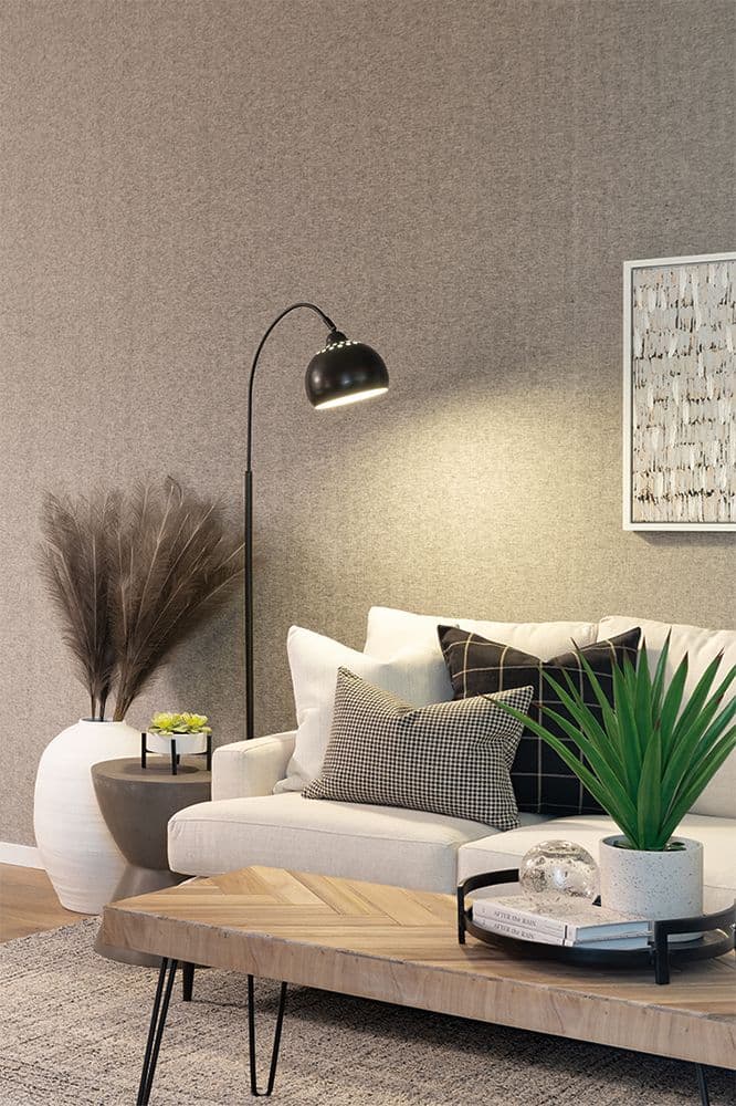 Southaven – Close-up of a living room corner with a beige sofa, patterned throw pillows, a floor lamp, and a large decorative vase with dried pampas grass.