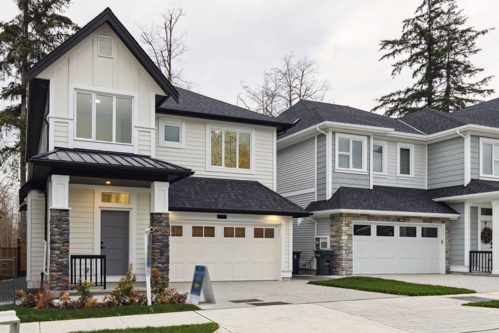 Brighton North – Exterior view of modern single-family or detached homes with garage, stone accents, covered front porch, and front yard landscaping.