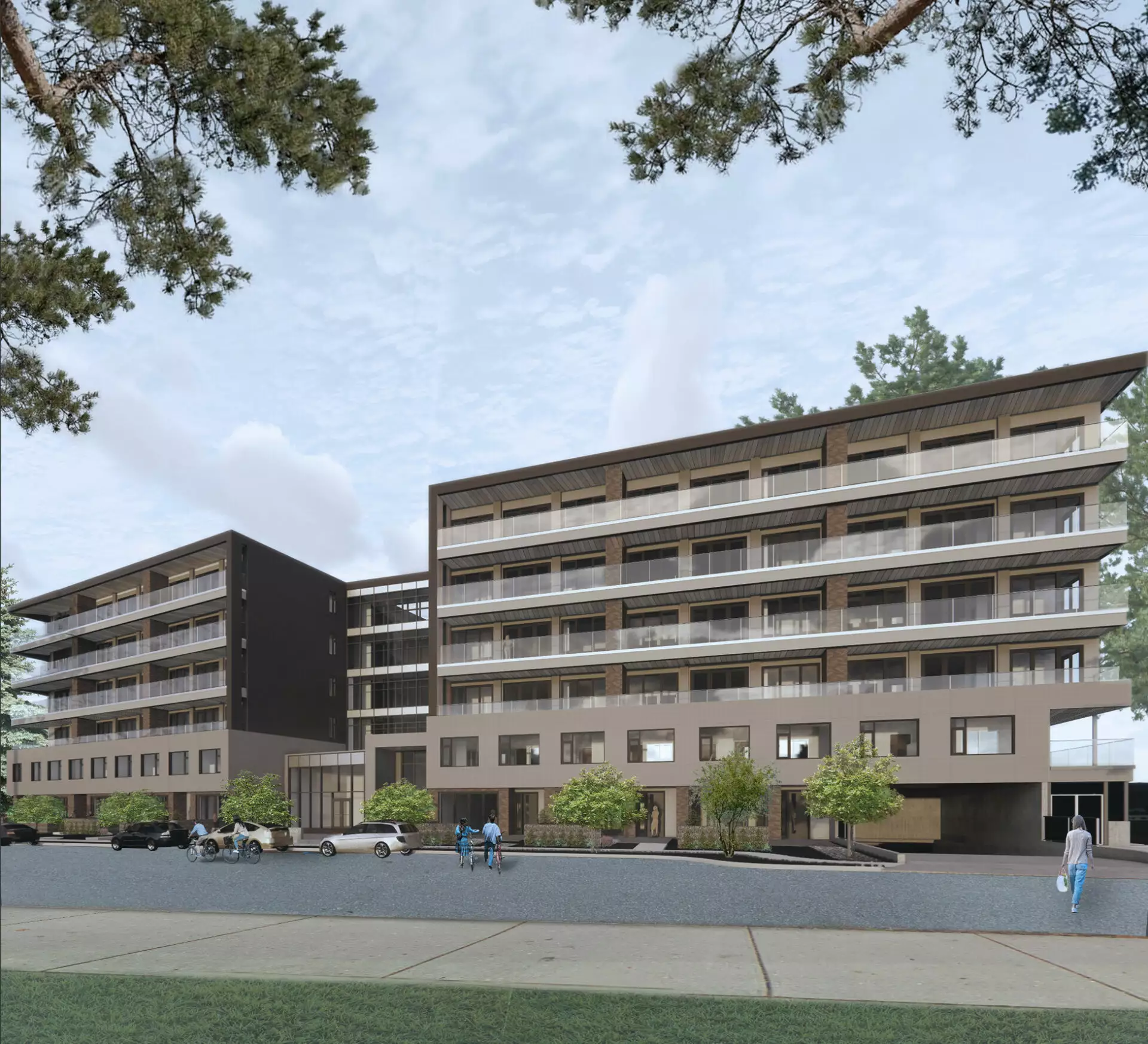 The Madison at Hunter Road – Street-level view of a mid-rise apartment building with brown and beige cladding and cyclists passing by.