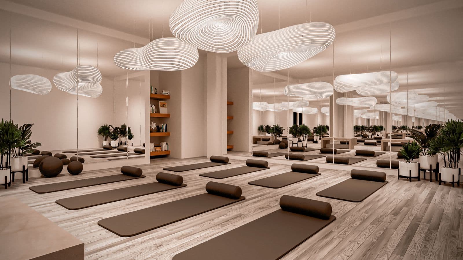 Elements – Fitness studio with rows of yoga mats and bolsters set up in front of mirrored walls, sculptural pendant lights, and potted plants.