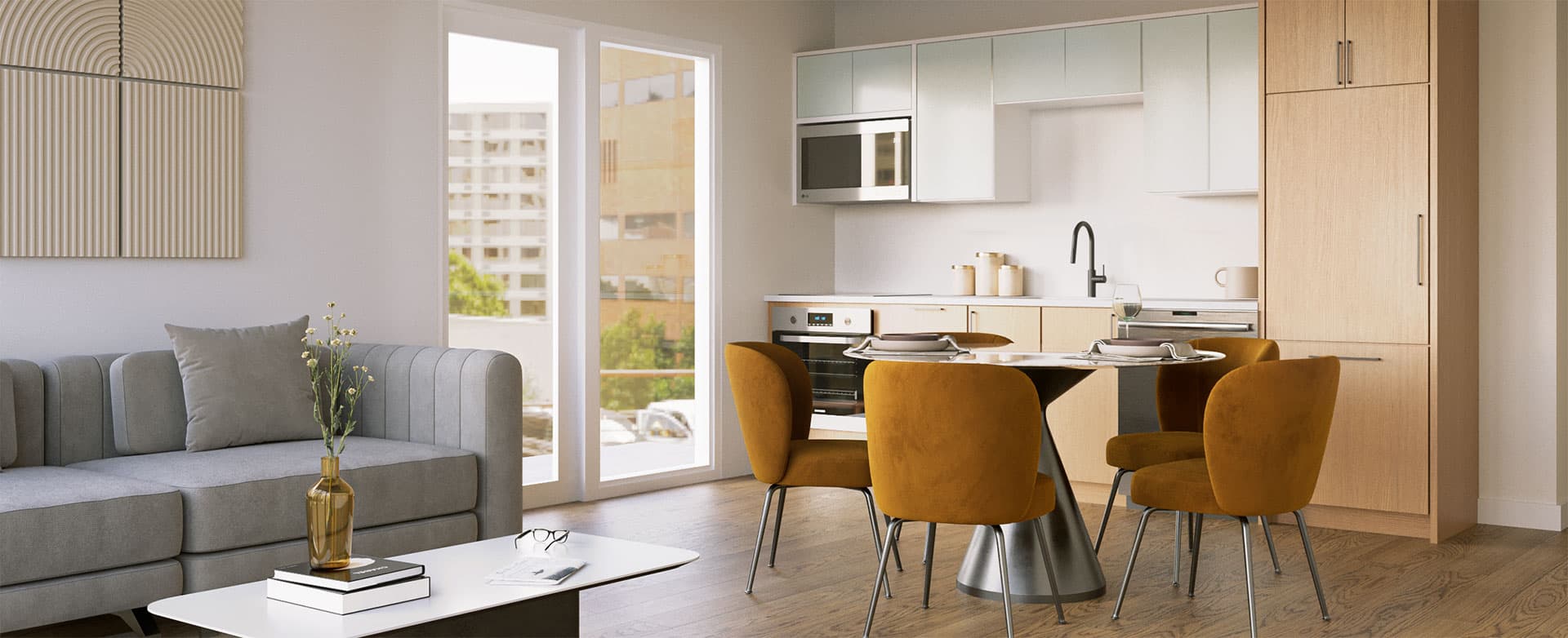 Elements – Open-concept kitchen and dining area with mustard velvet chairs around a round table, a grey sofa, and a balcony overlooking nearby buildings.