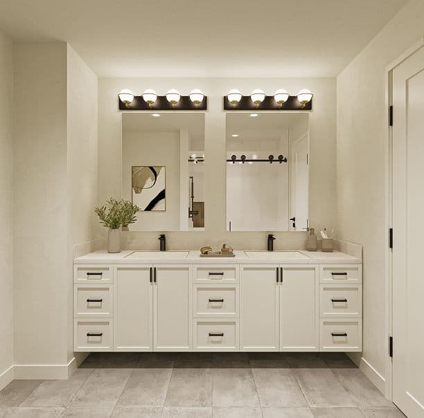 The Westminster – A modern bathroom features a floating white double-sink vanity with matte black hardware and white stone countertops set against grey tiled floors. Twin vertical mirrors are illuminated by multi-globe black vanity lights above, reflecting glimpses of an adjacent shower with black sliding door hardware.