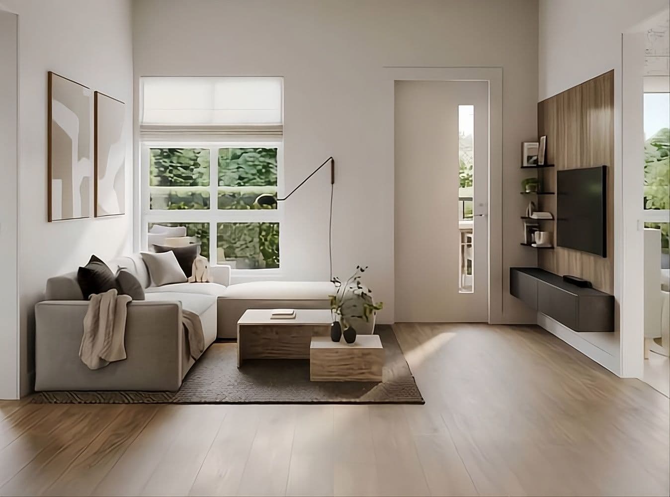Atlin – A modern, sunlit living room featuring a light-toned sectional sofa, wooden coffee tables, and light hardwood flooring. The space includes a wall-mounted TV over a wood-paneled accent wall, a doorway leading to a balcony or patio, and large windows looking out onto lush greenery.