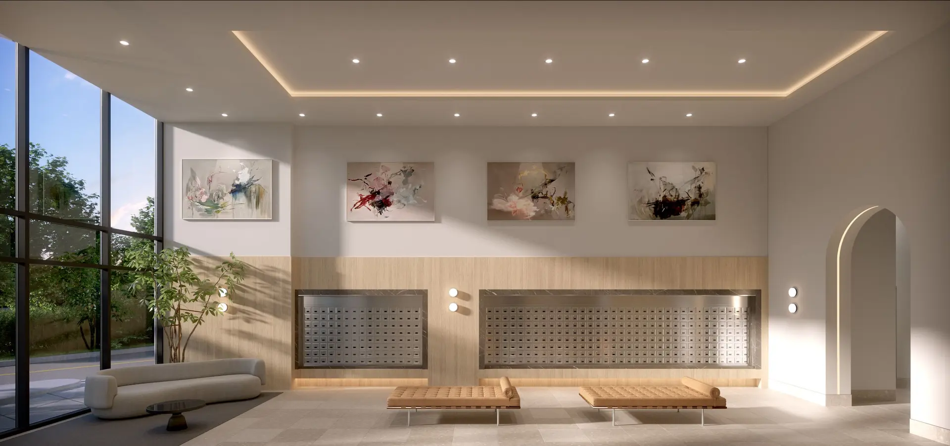 Elmwood – A bright and modern residential building lobby and mailroom area featuring large metallic mailboxes recessed into light wood wall paneling beneath a row of framed abstract artwork. The space includes a curved sofa near floor-to-ceiling windows, two leather daybeds, an arched doorway, and recessed ceiling lighting complemented by soft daylight.