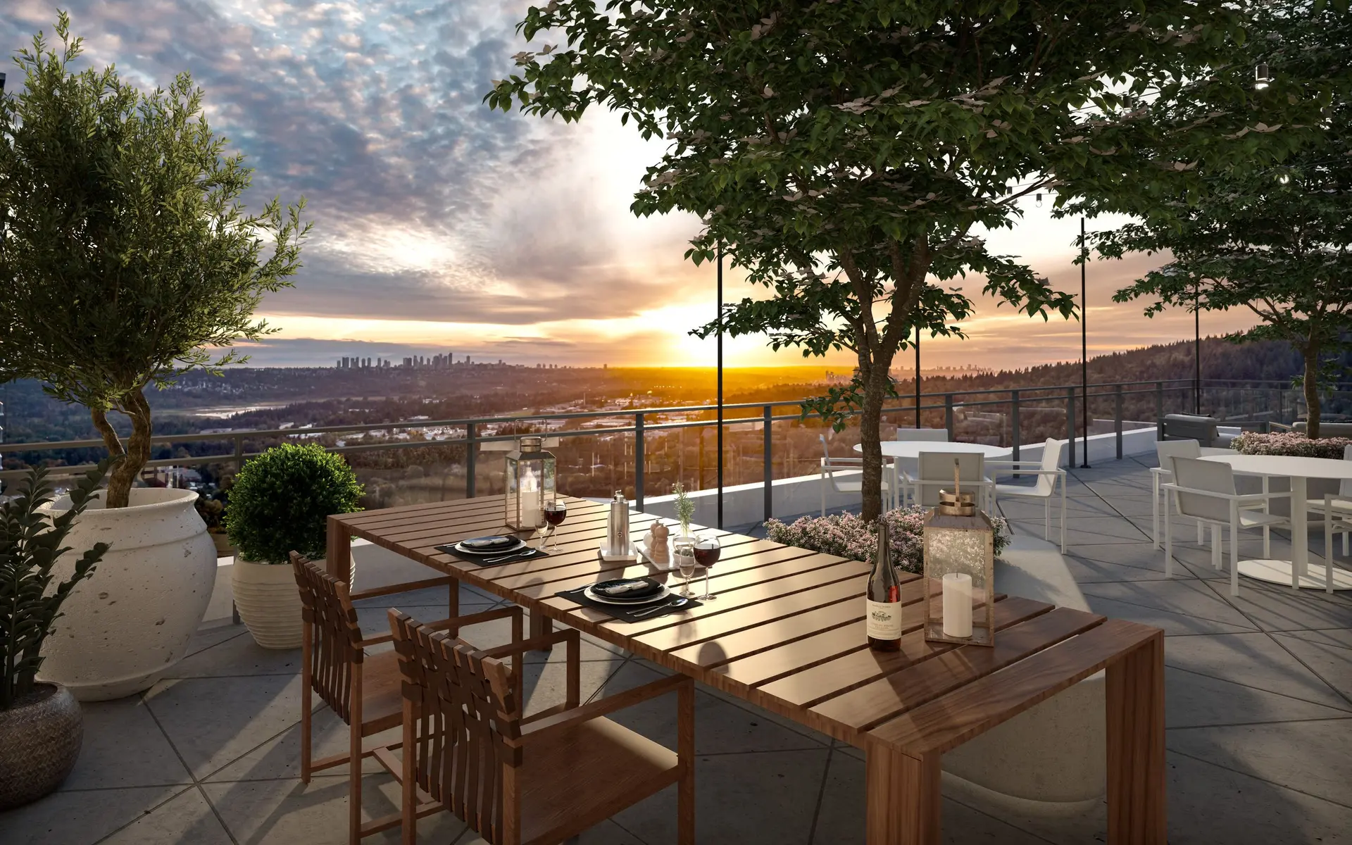 Elmwood – A rooftop terrace dining area features a slatted wood table set with wine and candles, potted plants, and leafy trees against a modern glass railing. The scene captures a warm golden sunset overlooking a panoramic view of distant city skylines, rolling forested hills, and waterways.