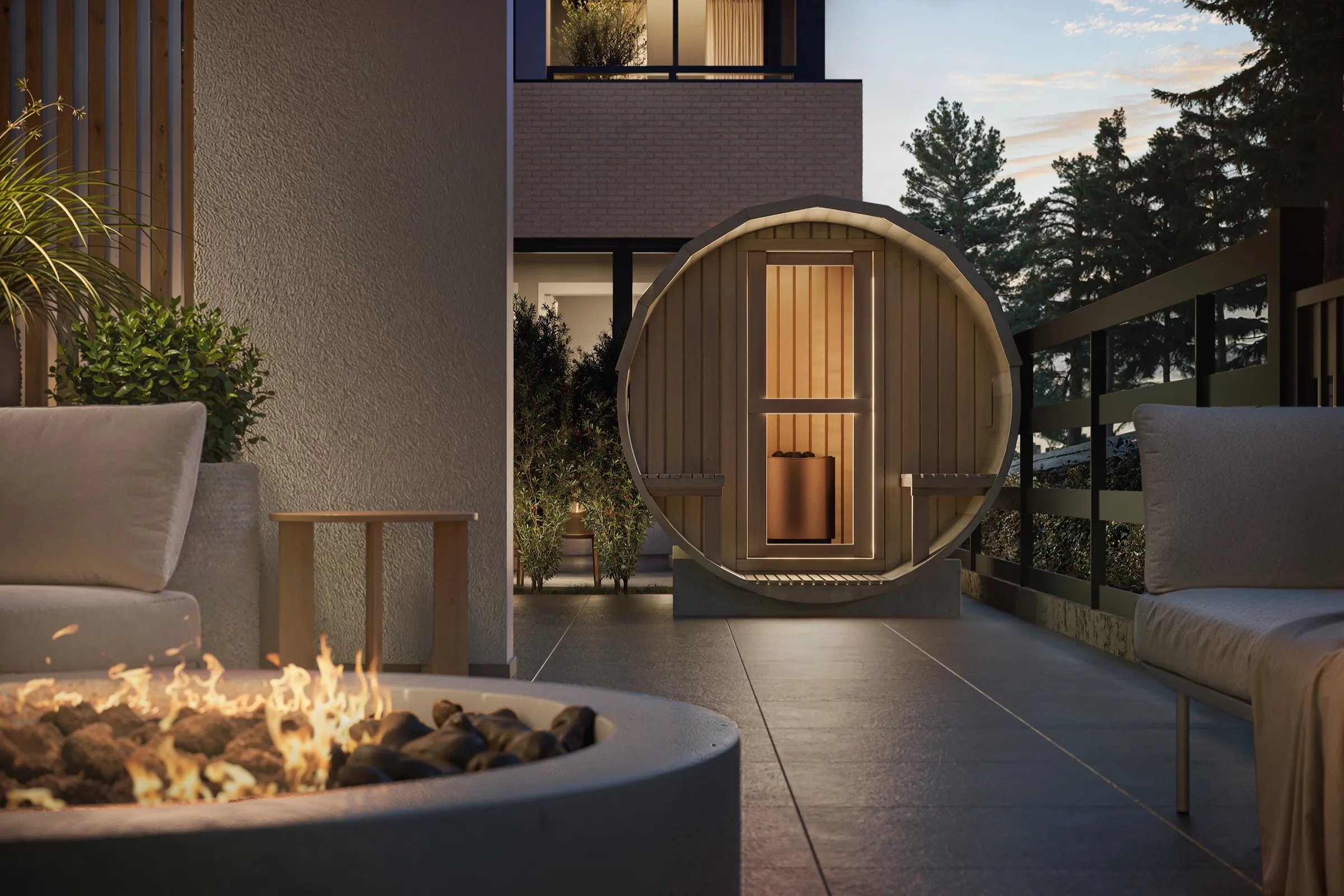 Muse – A modern outdoor terrace at twilight featuring a circular wooden barrel sauna with an illuminated interior and an open fire pit with dancing flames in the foreground. Surrounding the tiled patio are comfortable lounge chairs, lush potted greenery, and views toward pine trees under a dusk sky.