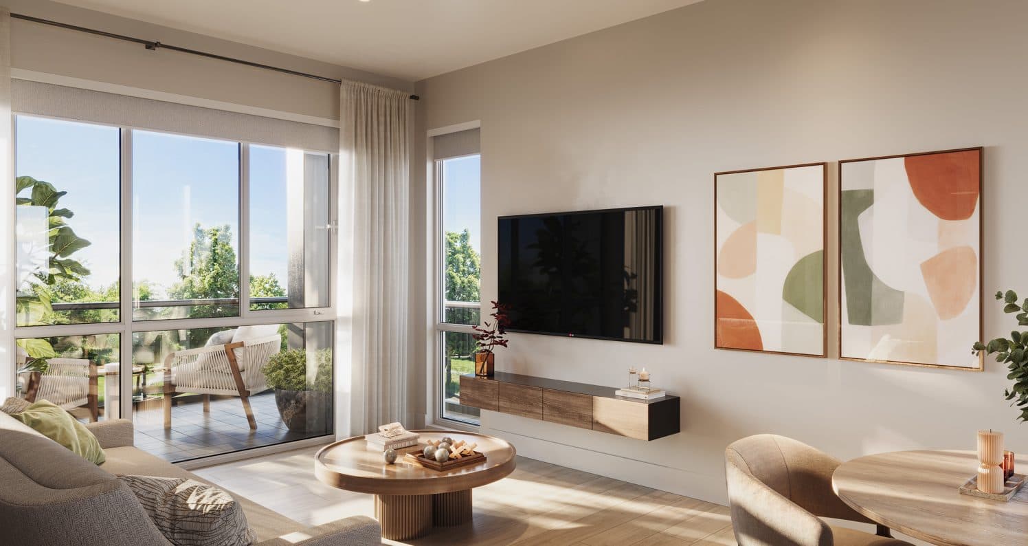 Infinity Garden – A modern, sunlit living room featuring light wood floors, a low-profile round coffee table, a floating wooden TV console, and abstract wall art. Large glass sliding doors open onto a private balcony furnished with outdoor seating, overlooking lush green trees on a clear day.