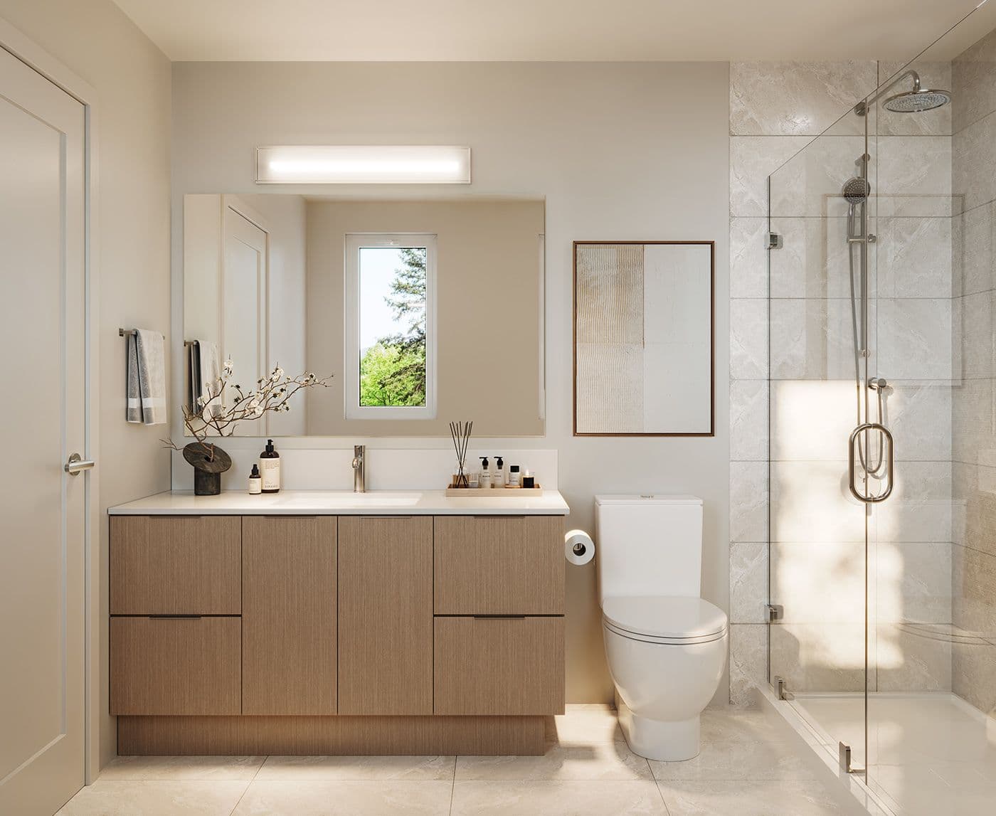 Infinity Garden – A modern residential bathroom featuring a light wood grain vanity with a white countertop, a large illuminated vanity mirror, and a sleek walk-in shower with frameless glass doors and stone-patterned wall tiles. Warm natural sunlight fills the space, reflecting off beige tile floors and neutral walls adorned with subtle artwork.