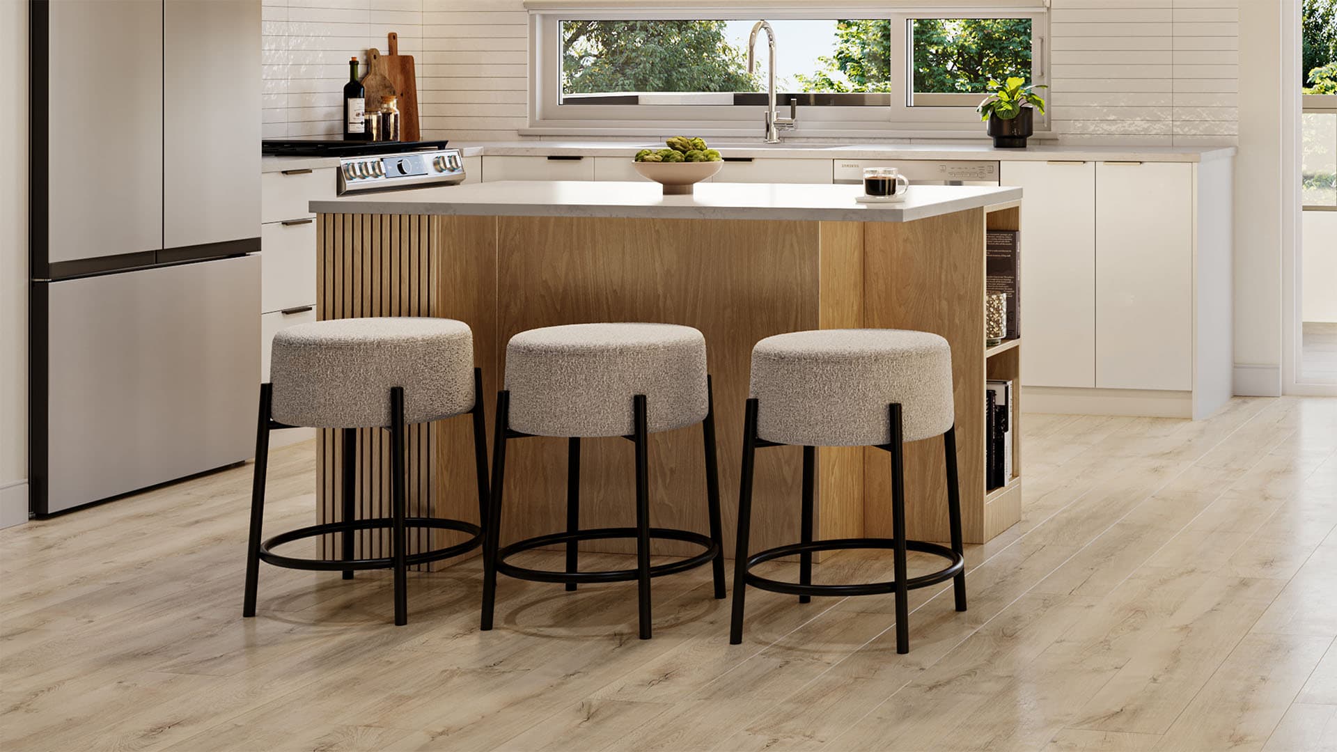 Everwood – A modern kitchen features a central wood-paneled island with three bouclé-upholstered barstools and light quartz countertops. The space is bathed in bright daylight from a horizontal window, highlighting white cabinetry, stainless steel appliances, and light wood flooring.