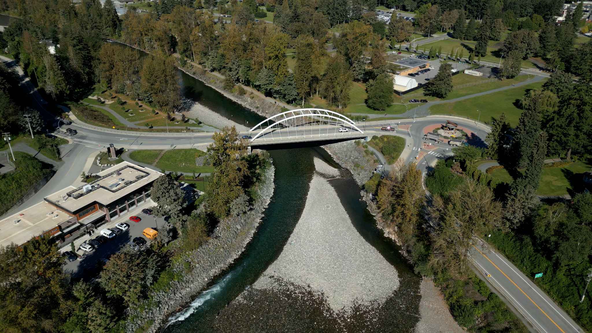 York Residences - Building C – A drone photo of a river with a white arched bridge, roads, and parkland, showing the broader area near the development.