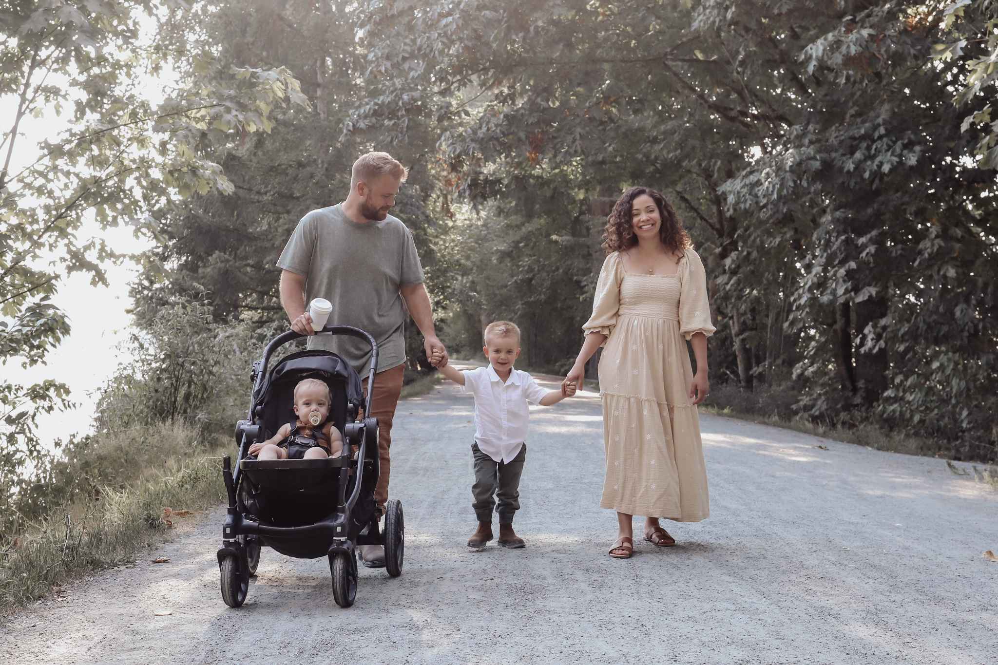 York Residences - Building C – A family of four walking hand-in-hand along a tree-lined gravel road; no building from the development is visible in this lifestyle shot.