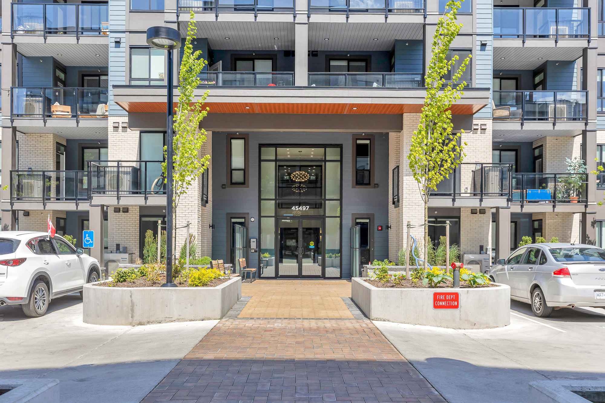York Residences - Building C – Close-up of the same condo building's main entrance with its glass doors, wood canopy, and address number 45497 above the door.