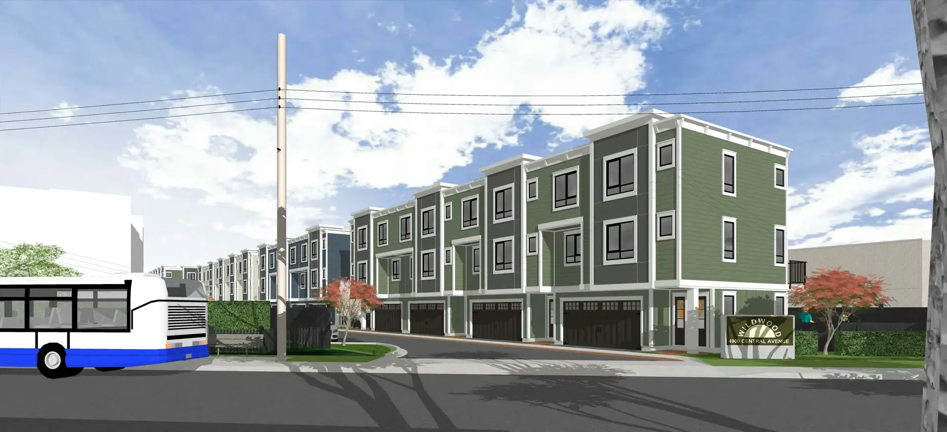 Wildwood Ladner – A rendering shows a row of multi-story modern townhomes clad in sage green and grey siding with white trim and ground-level garage entrances. A city bus drives past on the asphalt street in the foreground under a bright, partly cloudy sky.