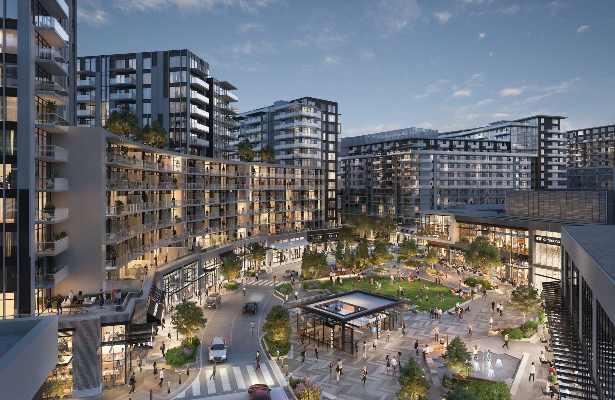 RC at CF Richmond Centre – An elevated view of a bustling multi-building residential and commercial development surrounding a central public plaza and green space. Mid-rise modern residential towers with glass balconies frame a lively pedestrian area featuring shops, outdoor dining, landcsaped lawns, a fountain, and a transit station entrance under a clear daytime sky.
