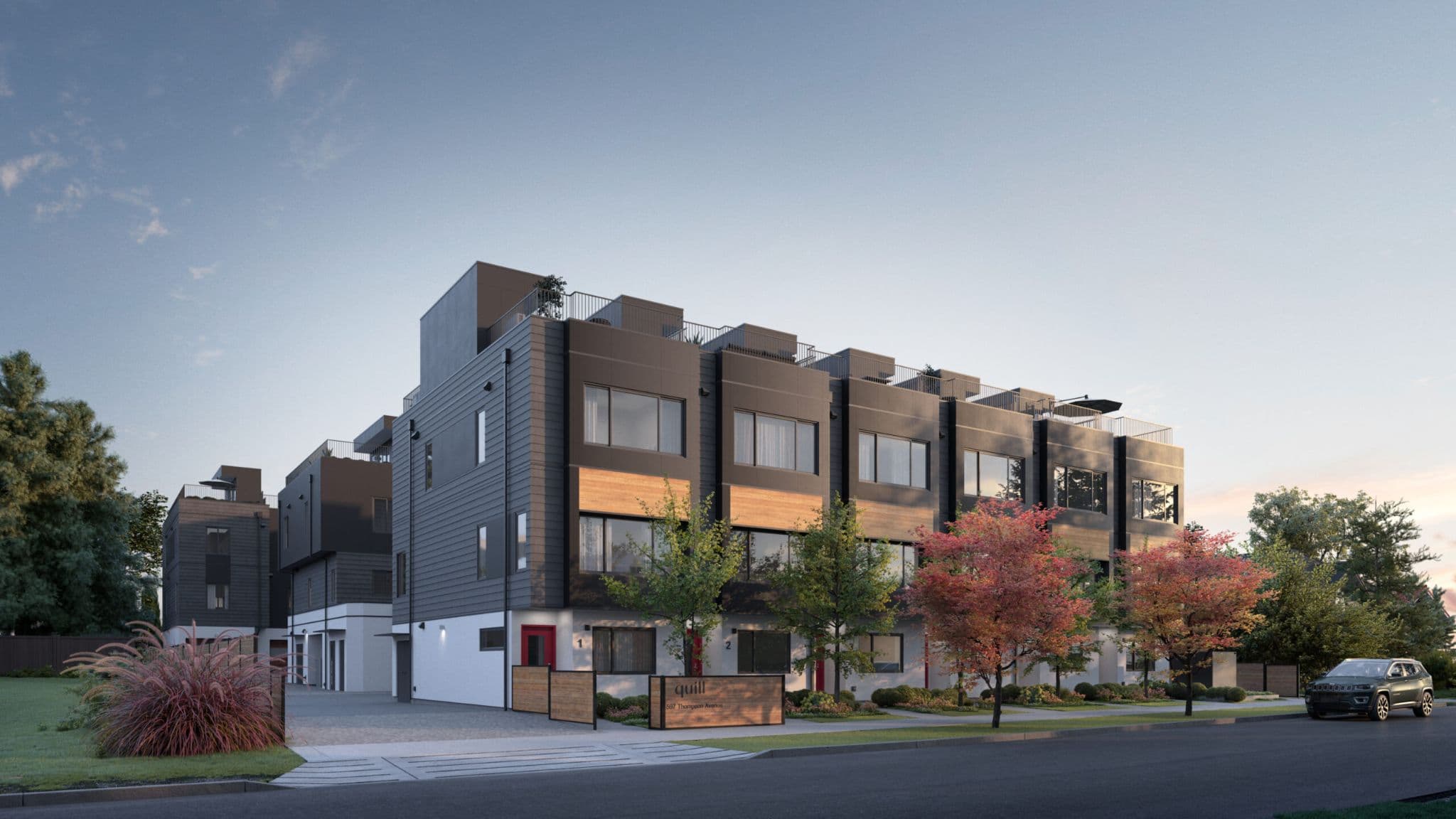 Quill – A three-to-four-story mixed townhome and condo building with dark cladding and wood accents, a 'quill' sign at the entrance, and autumn trees along the street at dusk.