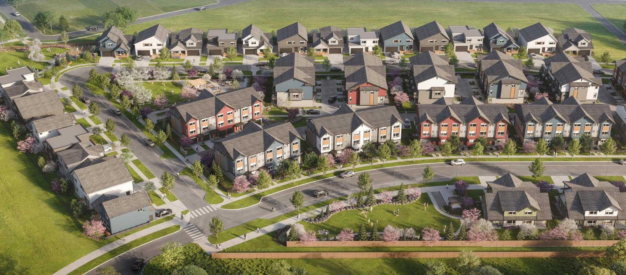 Boardwalk 7 – An elevated rendering shows a master-planned residential community featuring rows of modern single-family houses and townhomes with pitched roofs and colorful siding in shades of blue, red, grey, and white. Paved neighborhood streets with crosswalks wind through landscaped lawns, pocket parks, and flowering pink trees under bright daytime lighting.