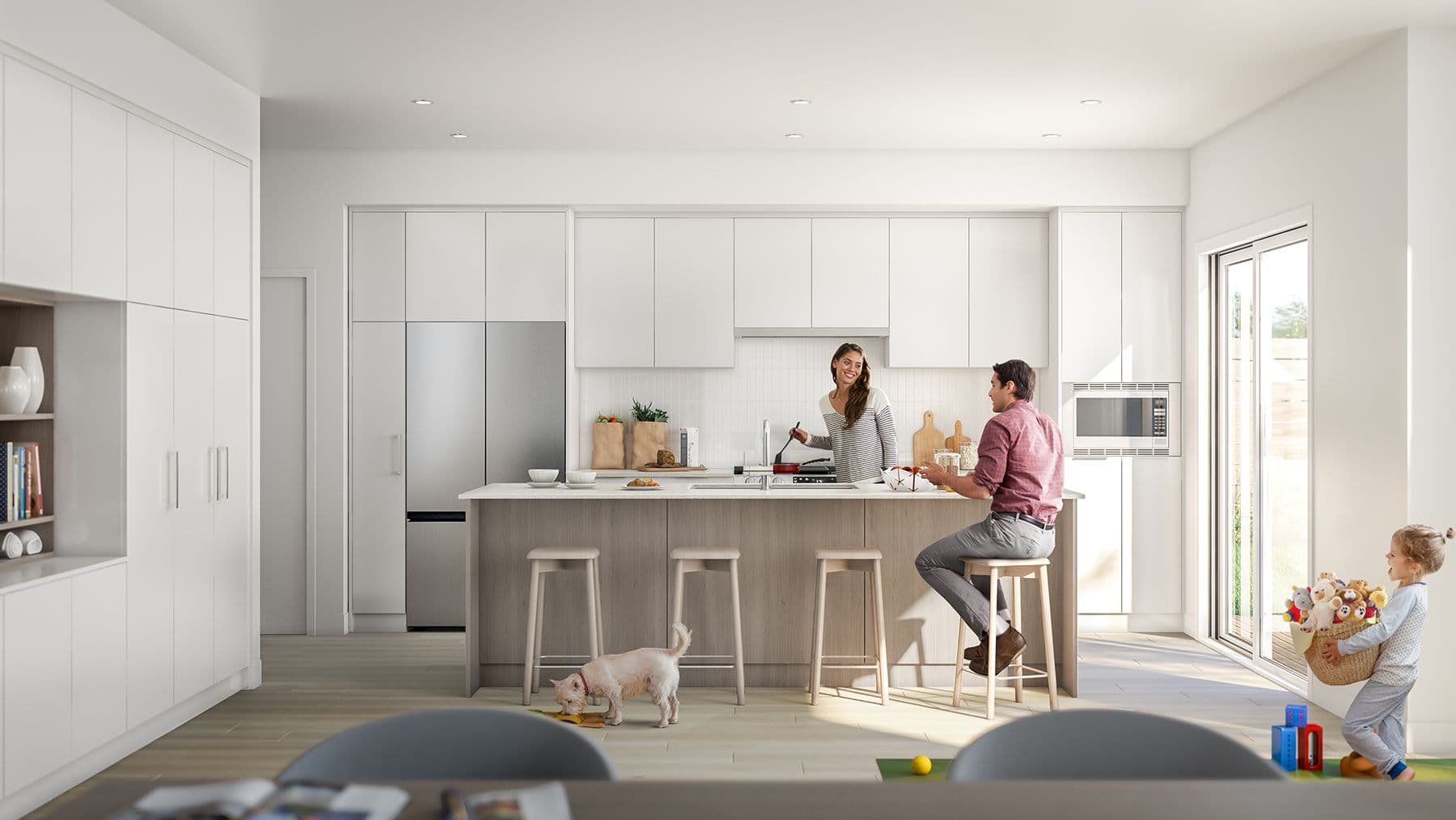Boardwalk 7 – A bright, open-concept kitchen features clean white flat-panel cabinetry, a light wood kitchen island with barstools, and integrated stainless steel appliances. A family and their small dog are interacting in the space, with natural daylight streaming in from a large sliding glass patio door.