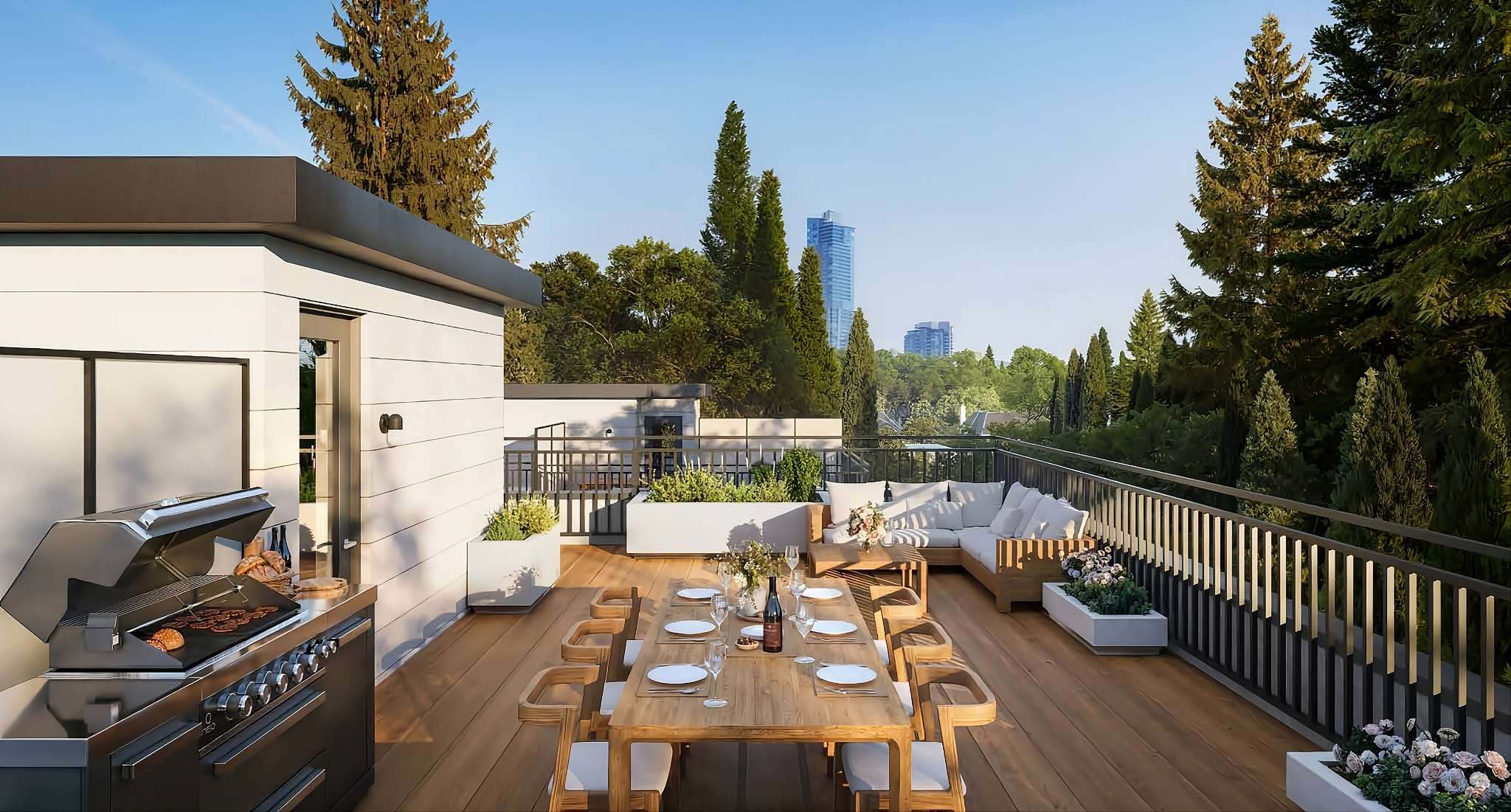Rouge Townhomes – Rendering of a rooftop deck with a built-in BBQ, a wood dining table set for a meal, and a corner sofa lounge, with a city skyline visible past the trees.