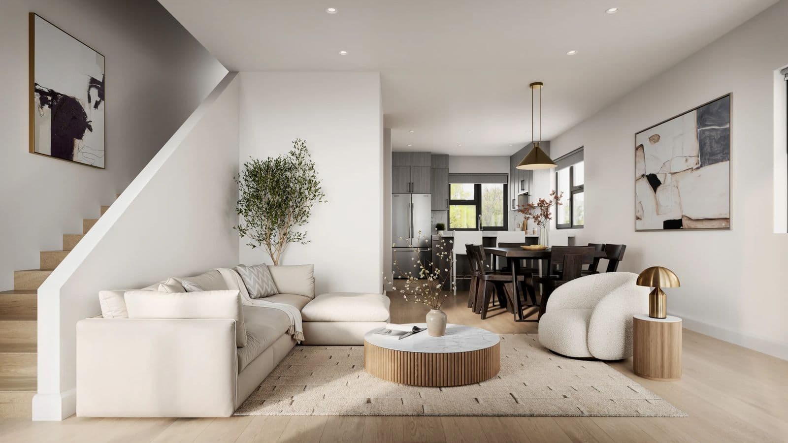 Rouge Townhomes – Rendering of an open-concept living room with a beige sectional sofa, round coffee table, and staircase, opening to a dining and kitchen area beyond.