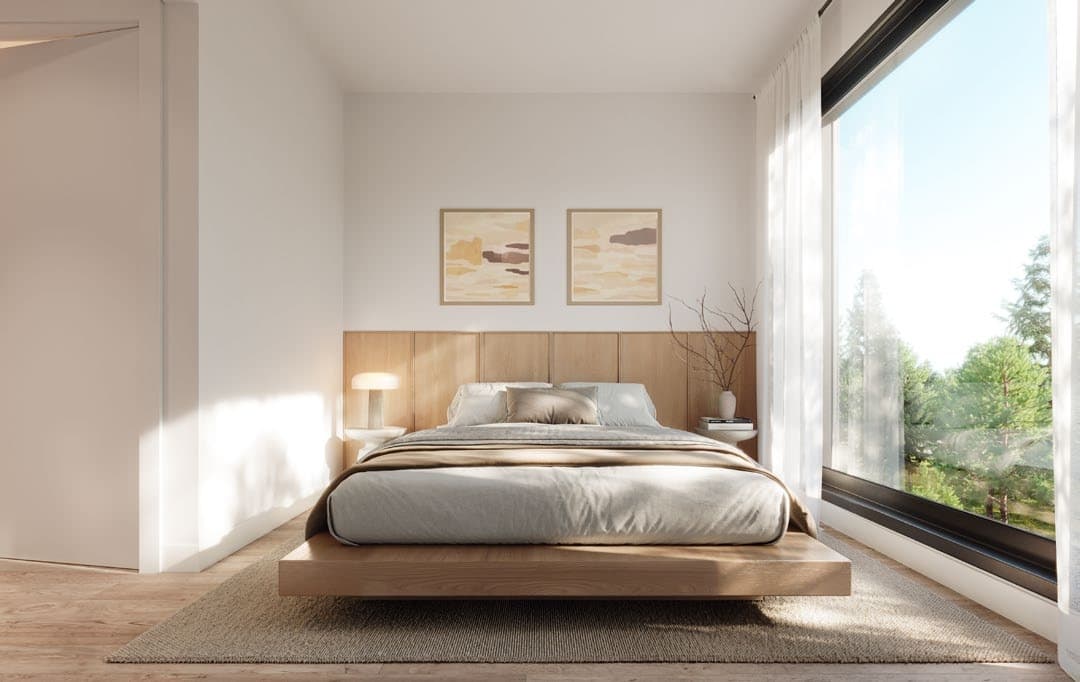 Line House – A bright, minimalist bedroom features a low-profile light wood platform bed with an integrated wood-paneled headboard and neutral bedding. Natural daylight pours in through a large floor-to-ceiling window overlooking lush green trees outside.