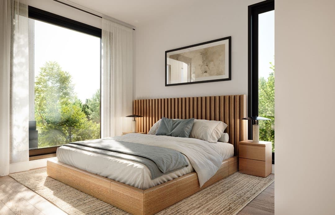 Line House – A sunlit, modern bedroom features a light wood platform bed with a vertical slatted headboard, dressed in neutral and muted blue-gray bedding. Large floor-to-ceiling windows frame views of lush green trees, filling the minimalist space with bright natural daylight.