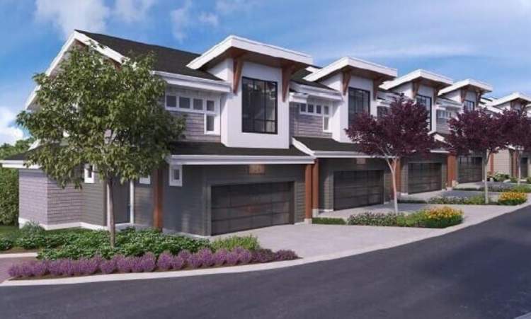Livewell – Rendering of a row of modern townhomes with grey siding, white gables, dark garage doors, and wood beam accents along a curved driveway.