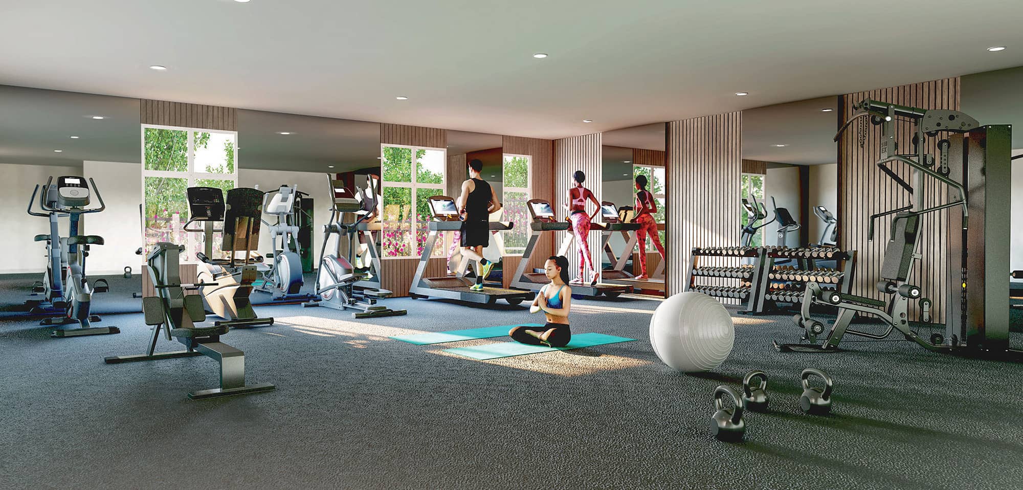 Ravir – Shared fitness room with treadmills, ellipticals, a weight rack, and a yoga mat area, with people exercising.