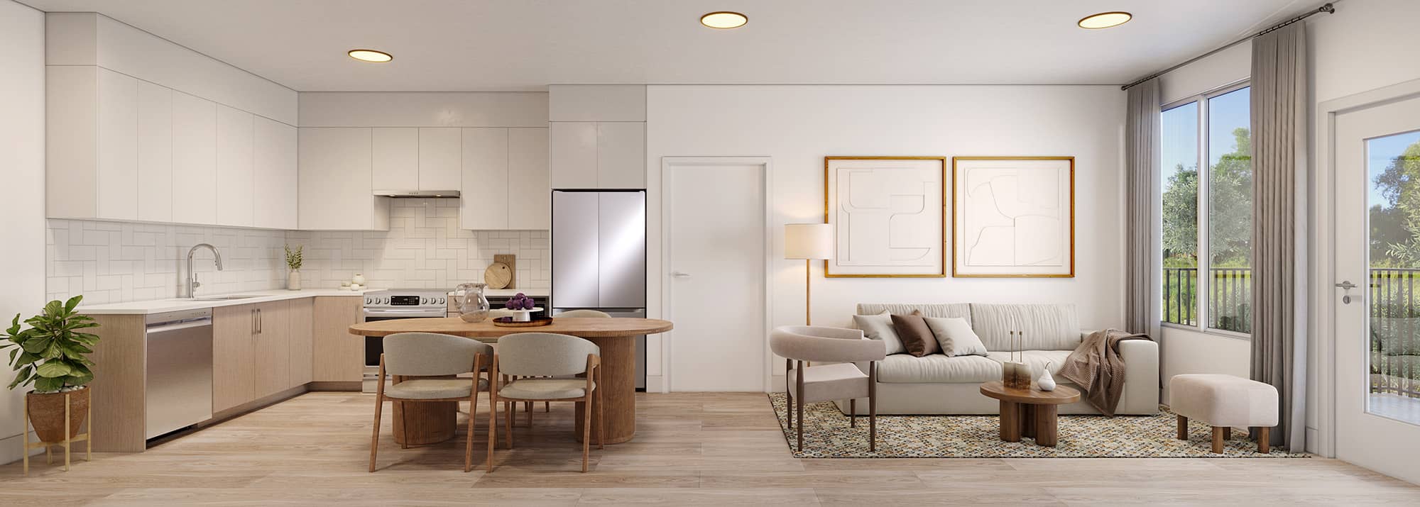 Ravir – Open-concept kitchen and living room with white cabinetry, a fridge, and a sofa with framed art on the wall, with a balcony visible through the window.