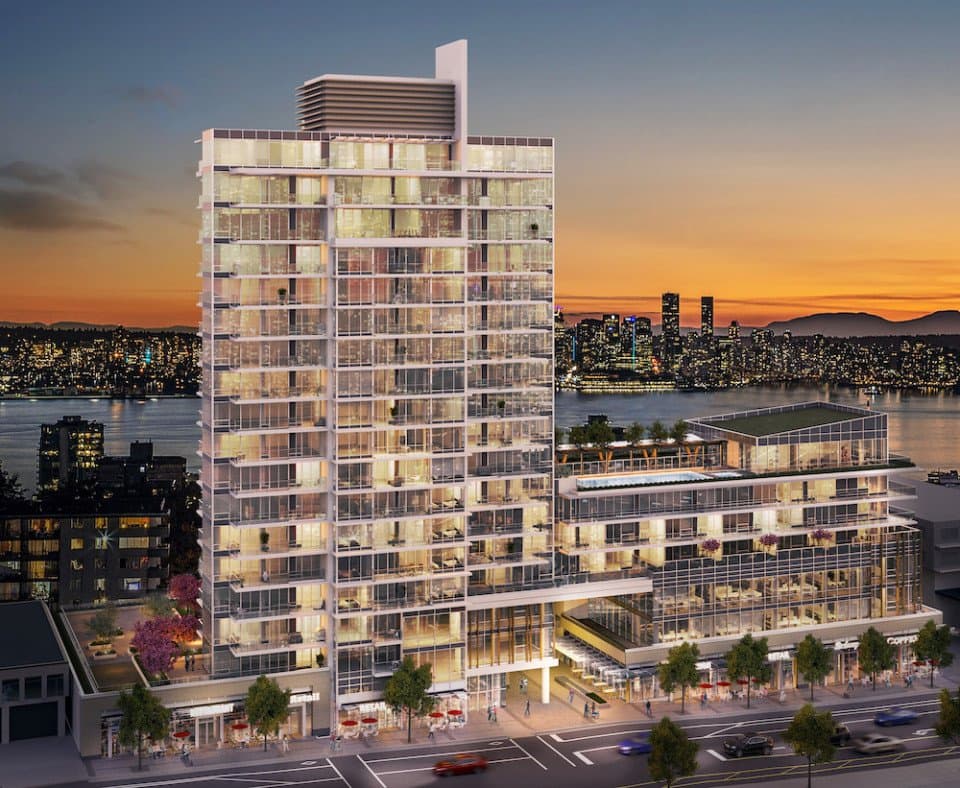Millennium Central Lonsdale Condos – A dusk exterior view of a glass high-rise residential tower with a rooftop pool deck, set against a waterfront city skyline sunset.