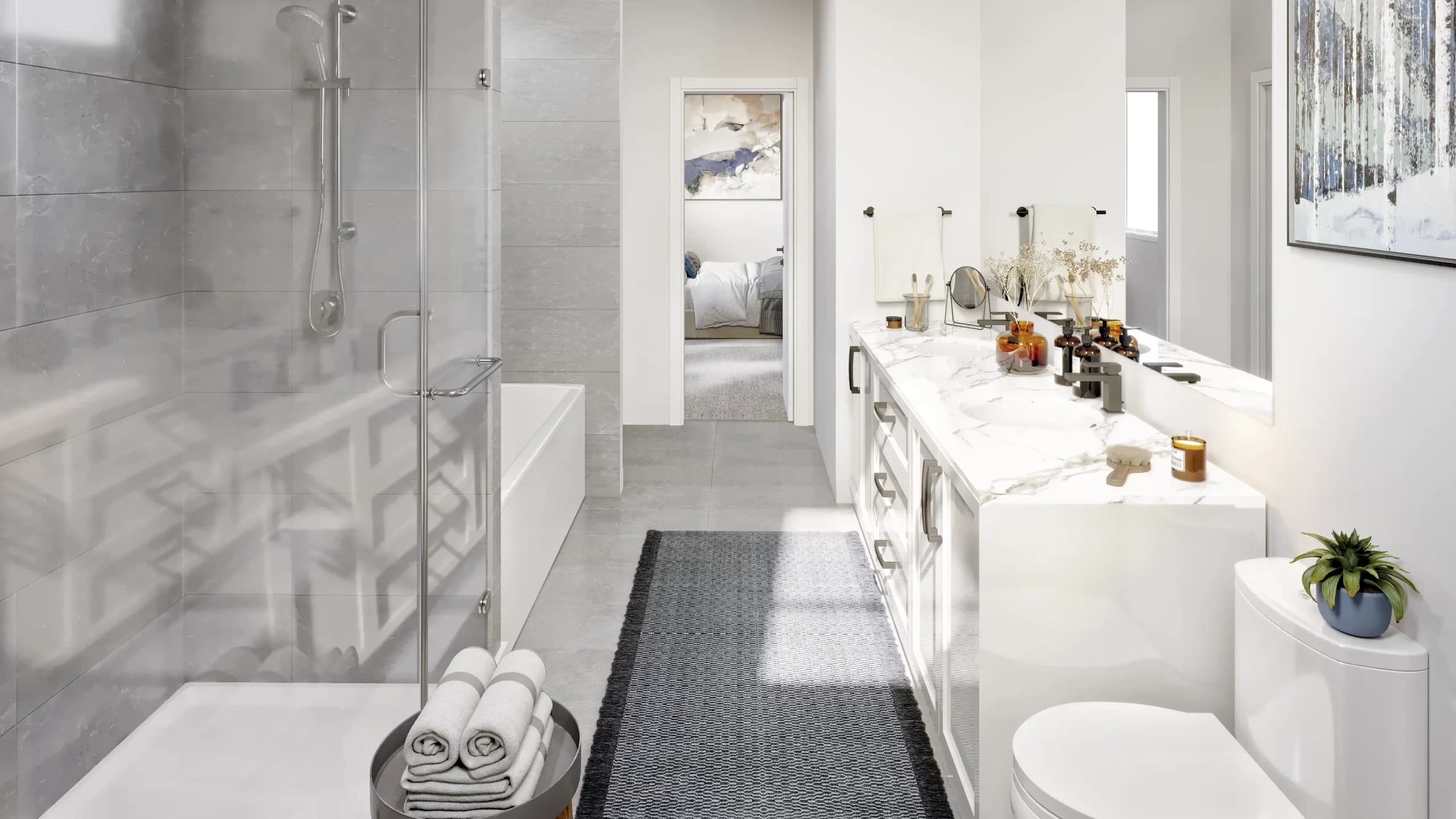 Bloom at Yorkson – A bright, modern bathroom featuring a long white marble-topped vanity, a glass-enclosed walk-in shower, grey tiled flooring, and a bathtub along the left wall. Natural light fills the space, which looks through an open doorway into an adjacent bedroom.