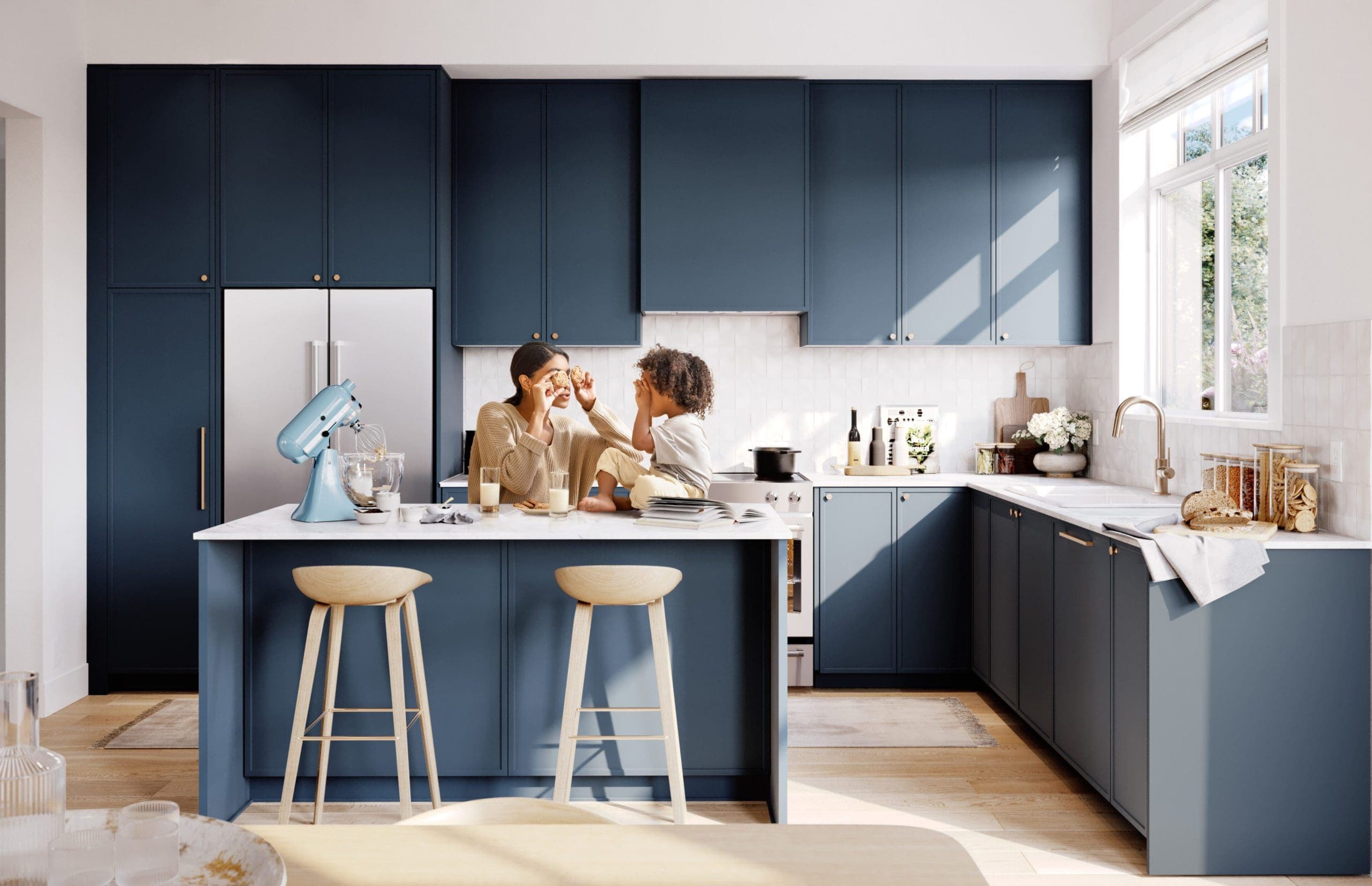 Riley Park – Lifestyle photo of a mother and child playing on a kitchen island with dark blue cabinetry, stainless fridge, wood barstools, and a stand mixer, in a white-tiled kitchen.
