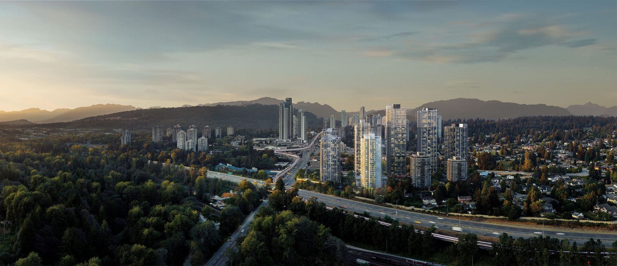 SOCO Two – A wide sunset aerial view of a cluster of highrise towers along a highway, with forested hills and mountains in the background.