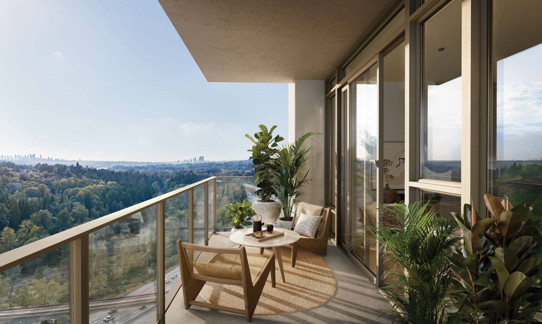 SOCO Two – A high-floor balcony furnished with wood chairs and a coffee table, overlooking a forested valley with a distant city skyline.