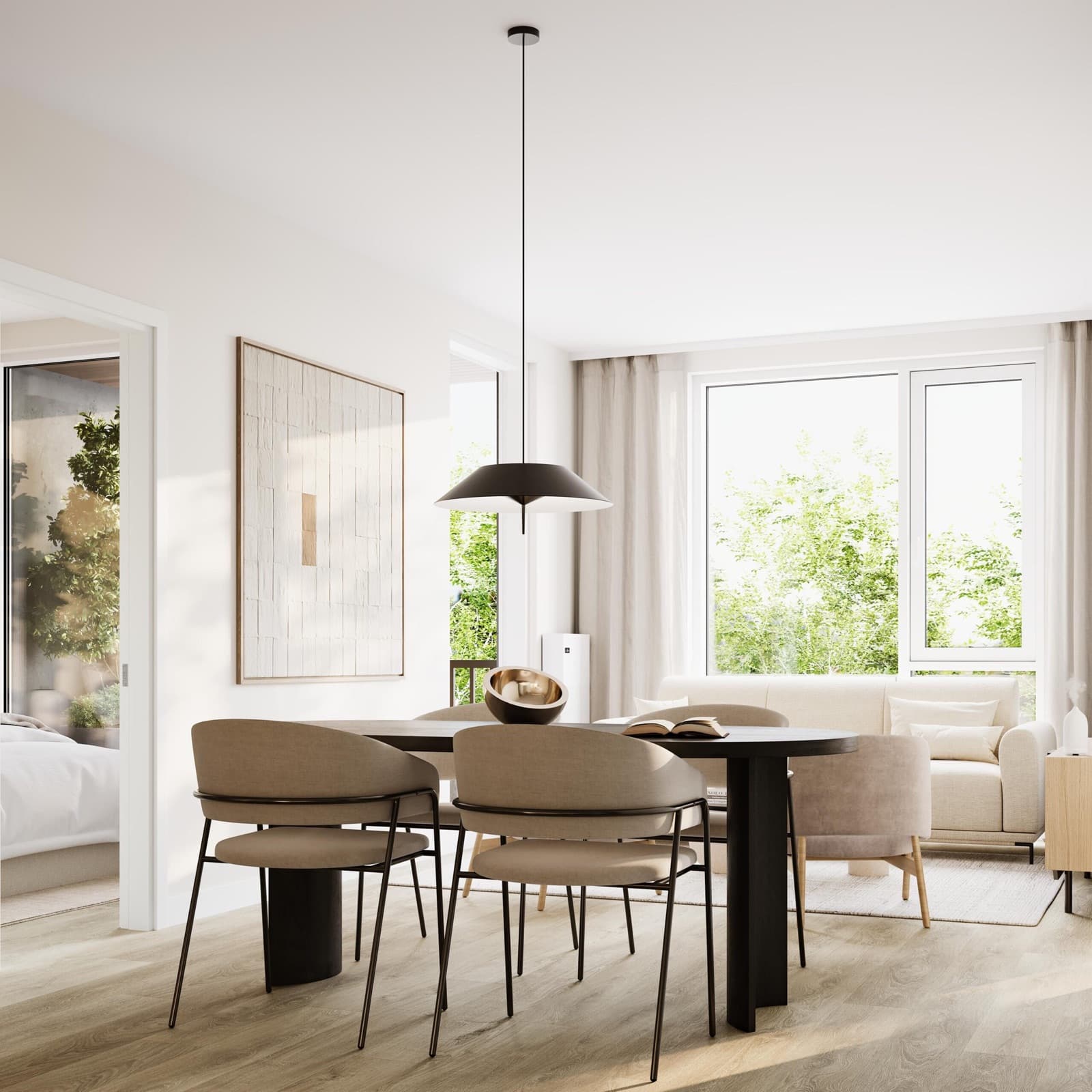 Chapter – Open-concept dining and living room with a round black dining table, upholstered chairs, a beige sofa, and large windows looking onto trees.