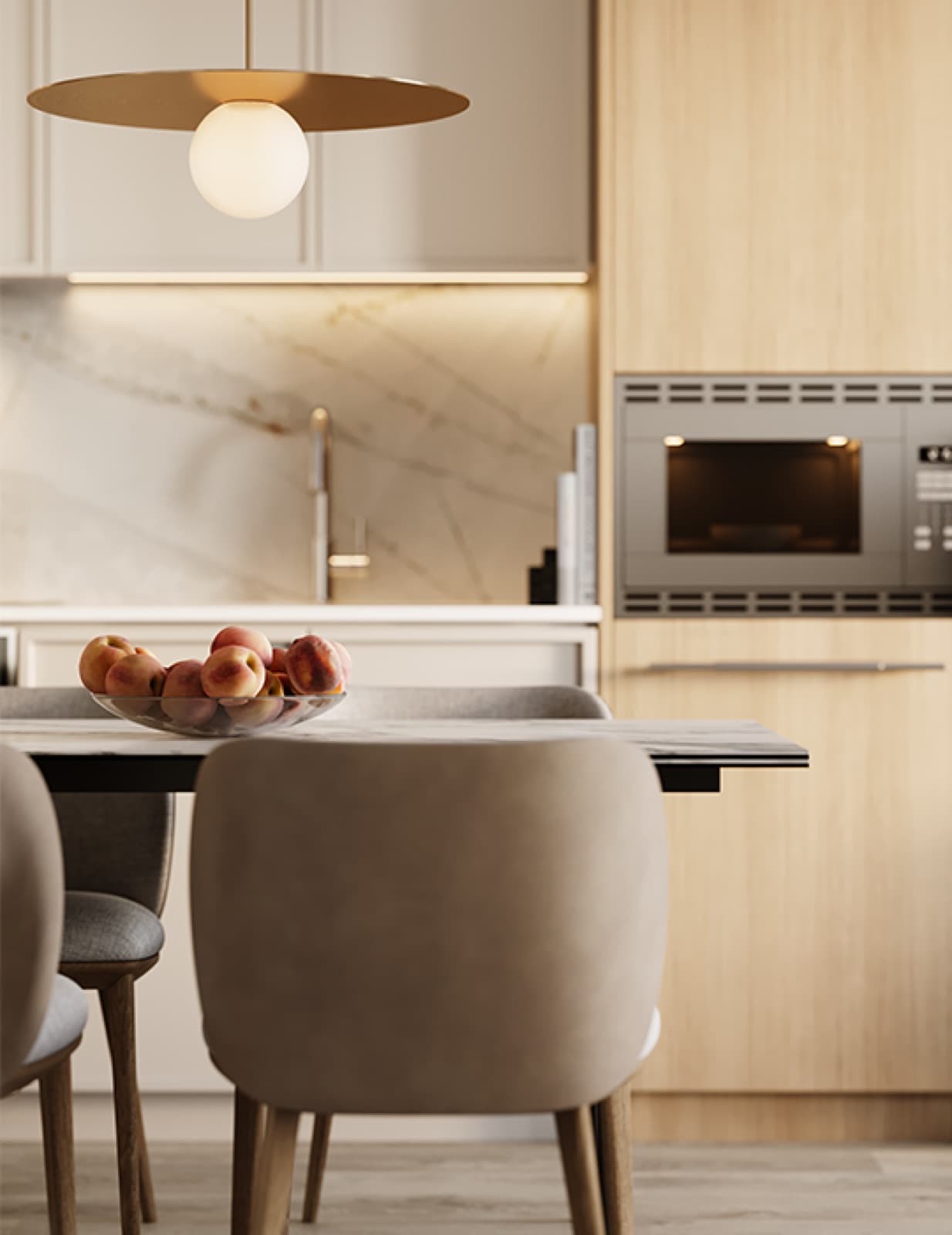 Chapter – Close-up of a dining table with a bowl of peaches, marble backsplash, built-in oven, and a brass pendant light overhead.