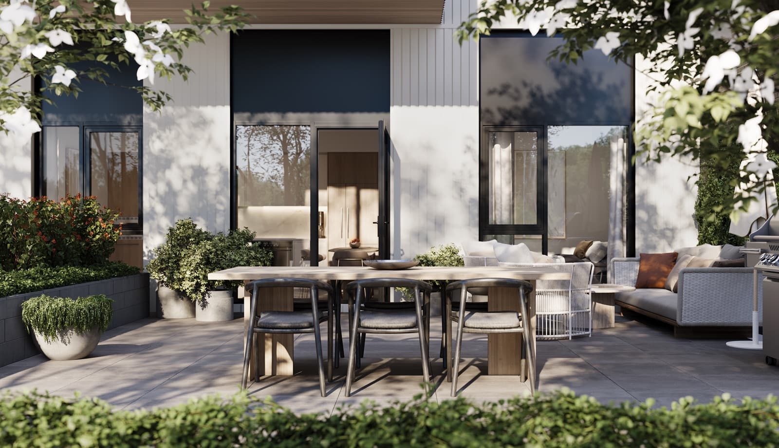 Chapter – Private patio with a dining table and lounge seating attached to a unit, surrounded by greenery and potted plants.