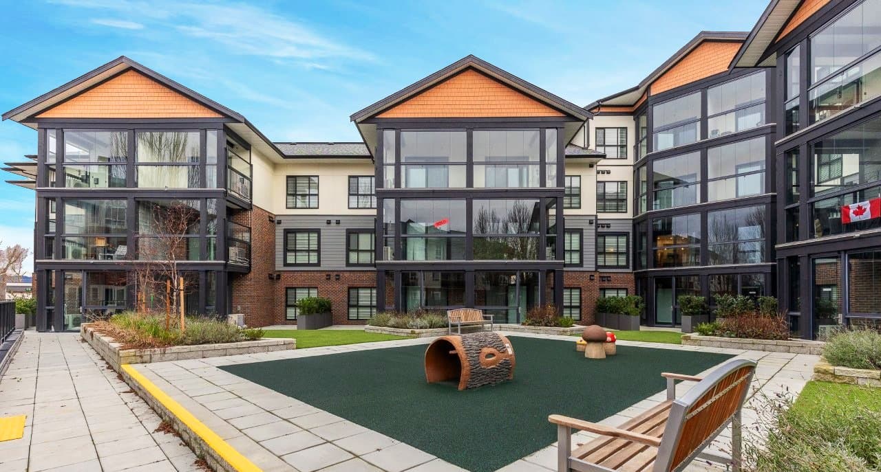 Mountainview Lane – Interior courtyard with a children's play area, landscaped planters, benches, and surrounding glass-fronted units and balconies, viewed from a different angle.