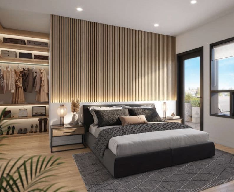 Oakhaus – Rendering of a primary bedroom with a wood slat accent wall, a walk-in closet with hanging clothes and shelving, and a glass door leading to a private balcony.